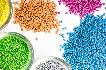 Diversos tipos de polímeros coloridos e granulados que representam os conceitos básicos do curso de materiais plásticos da Escola LF
