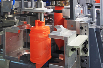 Empresa de sopro convencional onde sai um galão de plástico produzido em uma máquina sopradora com parison que representa o curso de sopro da escola lf